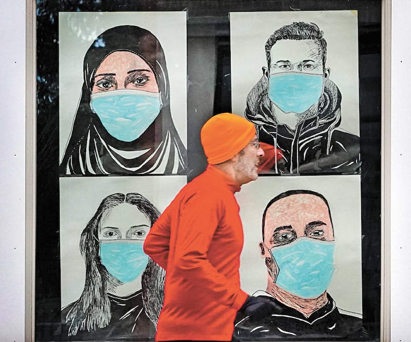 En Lewiston, Maine, un corredor pasa ante un vitral en el que se ven representaciones de personas con cubrebocas. ROBERT F. BUKATY. AP