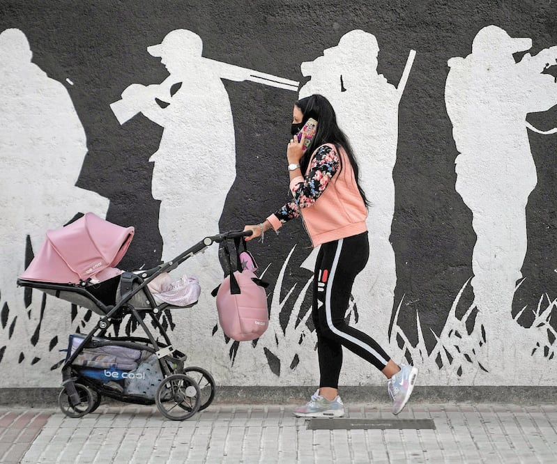 Una mujer empujando una carriola en el municipio de Fuenlabrada, Madrid. Casi un millón de habitantes de la región ya se encuentran desde el lunes en un régimen de movilidad restringida para intentar contener la segunda ola del coronavirus. EMILIO MORENAT