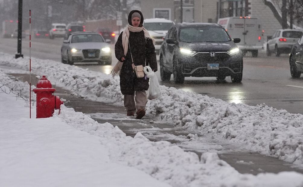 Una mujer camina por una acera con una gran cantidad de nieve en Wheeling, Illinois, el lunes 1 de diciembre de 2025. Foto: AP