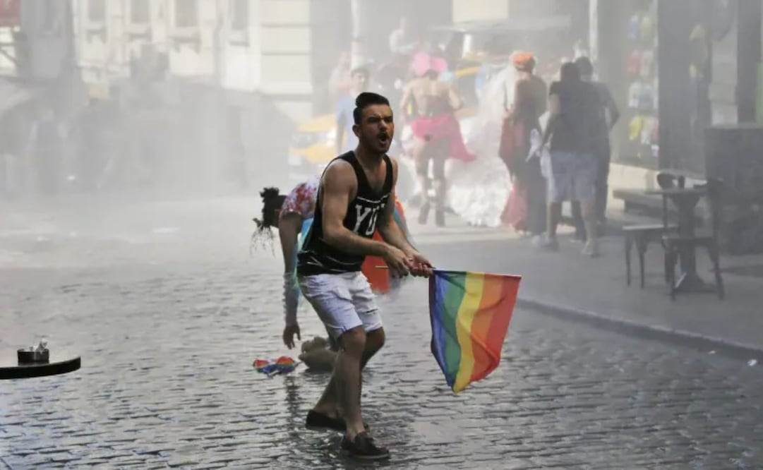 Un participante resiste mientras otros huyen durante una manifestación por los derechos de las personas homosexuales, bisexuales, lesbianas y transexuales que fue disuelta por la policía con un cañón de agua y gases lacrimógenos en Estambul, Turquía, el domingo 28 de junio de 2015. Foto: AP/Archivo