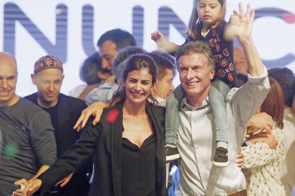 El candidato de la alianza opositora Cambiemos, Mauricio Macri, celebra ante sus seguidores, en Buenos Aires, en compañía de su esposa e hija (AGUSTÍN MARCARIAN. REUTERS)