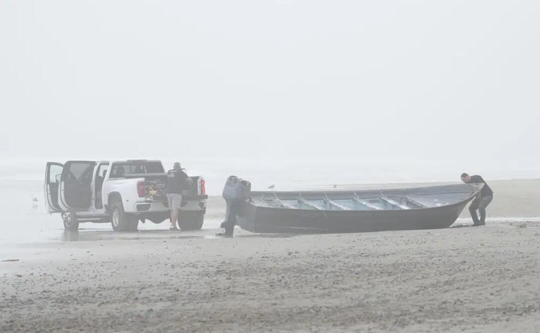 El salvador de botes Robert Butler, a la izquierda, y KC Ivers, a la derecha, se preparan para mover uno de los dos botes en Blacks Beach. Foto: AP