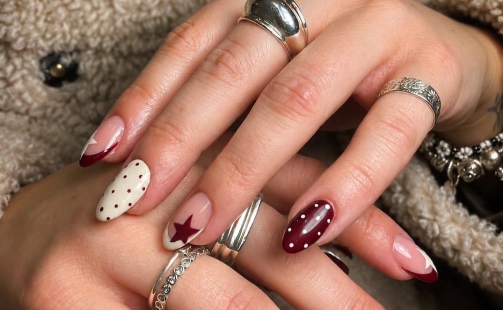 Borgoña profundo, estrellas, french invertido y pequeños detalles. Foto: Instagram @trazo.seguro.nails