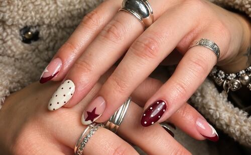 Borgoña profundo, estrellas, french invertido y pequeños detalles. Foto: Instagram @trazo.seguro.nails