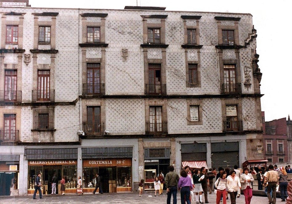 Una fotografía de la Casa de las Ajaracas en los años ochenta. La toma corresponde a la calle República de Guatemala y se alcanzan a distiguir diversos locales comerciales en la planta baja del inmueble, mientras que ya la fachada presentaba varios daños estructurales. Colección Villasana.