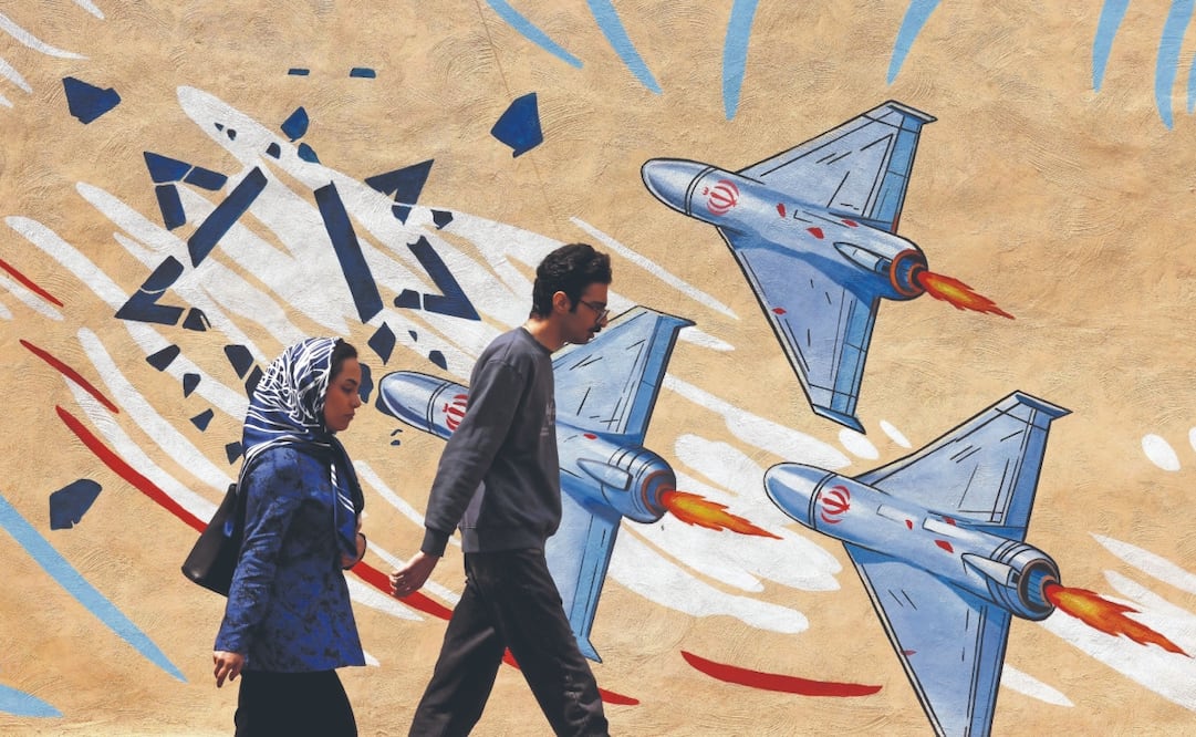 Iraníes caminan junto a un mural antiestadounidense y antiisraelí, en Teherán. El régimen advirtió a EU contra el bloqueo que mantiene a sus buques. Foto: Atta Kenare/ AFP