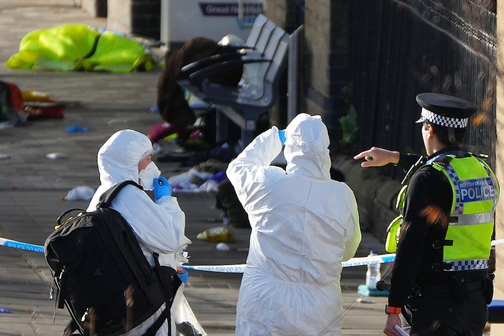 Investigadores forenses revisan el área donde viajero dejaron sus pertenencias tras un apuñalamiento masivo en un tren, en Huntingdon, Inglaterra. FOTO: KIRSTY WIGGLESWORTH. AP