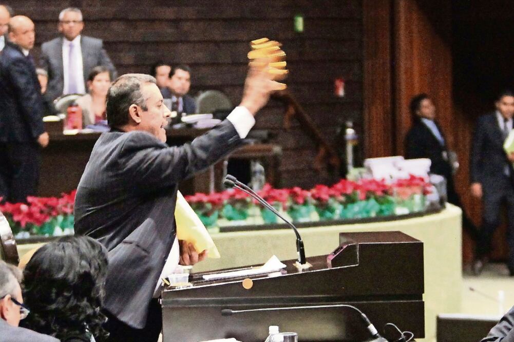 Mario Ariel Juárez, diputado de Morena, lanzó monedas de chocolate al pleno, señalando que sus homólogos estaban vendidos por avalar el PensionISSSTE (LUCÍA GODÍNEZ. EL UNIVERSAL)