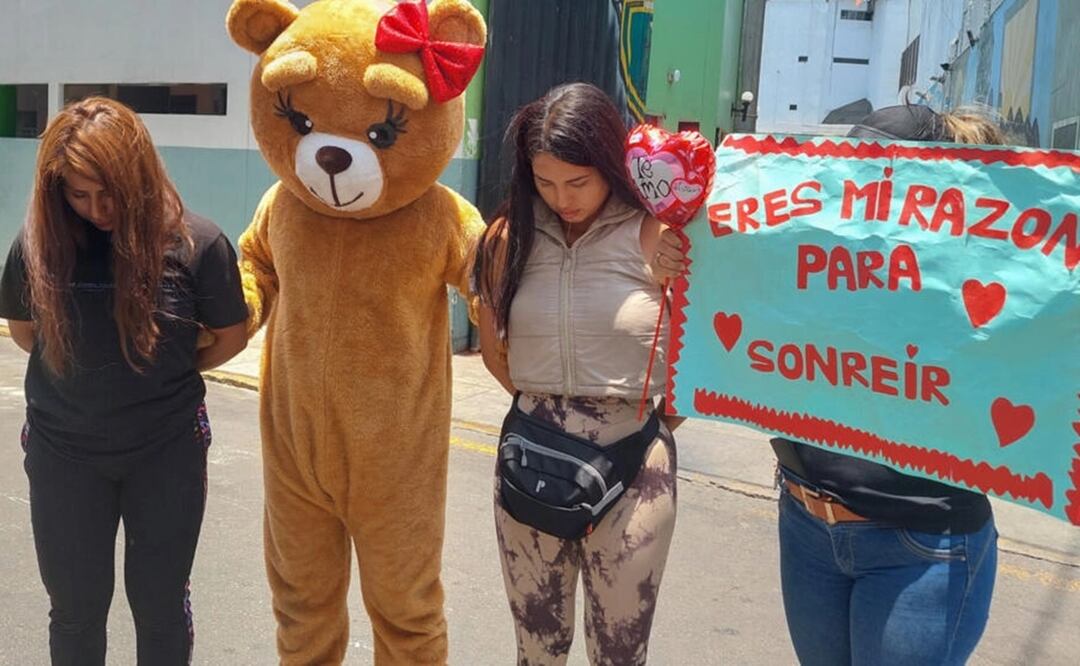 El policía disfrazado de oso posa junto a las detenidas en la operación contra el tráfico de drogas el 14 de febrero de 2024 en Lima. Foto: AFP