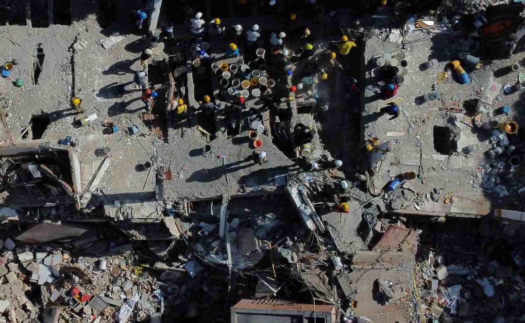 Voluntarios y rescatistas utilizan cubos para retirar los escombros de un edificio derrumbado un día después de un sismo que remeció Cali, Colombia, el 11 de agosto de 2026. Foto: AP