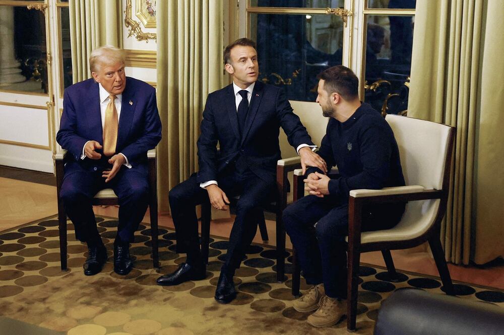 El presidente de Francia, Emmanuel Macron (centro), el mandatario de Estados Unidos, Donald Trump (i), y el presidente de Ucrania, Volodimir Zelensky, esperan para posar antes de una reunión en el Palacio Presidencial del Elíseo en París. Foto: AFP