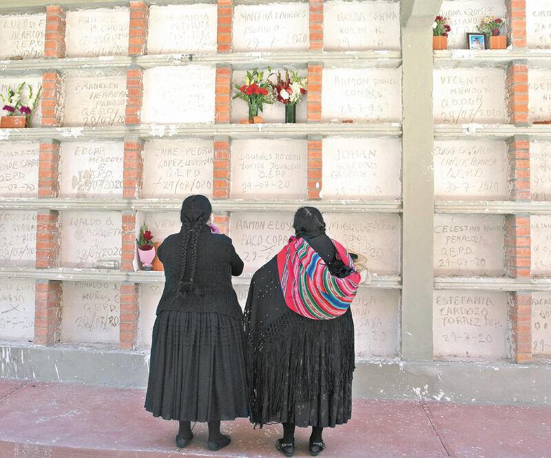 Bolivianas visitan por primera vez las tumbas de sus familiares que murieron por Covid, en La Paz. Al golpe de la pandemia, el país suma la crisis política. Foto: JUAN KARITA. AP