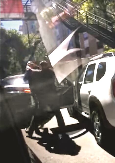 En redes sociales circula un video donde se observa cómo el conductor de una camioneta blanca fue bajado y golpeado por un guardaespaldas que escoltaba a un Ferrari de color rojo, placas PYU5755, del estado de Morelos (IMAGEN TOMADA DE REDES SOCIALES)