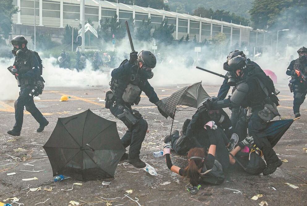 Policías antidisturbios se enfrentaron ayer contra los manifestantes a favor de la democracia en Hong Kong, en el Día Nacional por el 70 aniversario del régimen comunista en China. ISAAC LAWRENCE. AFP