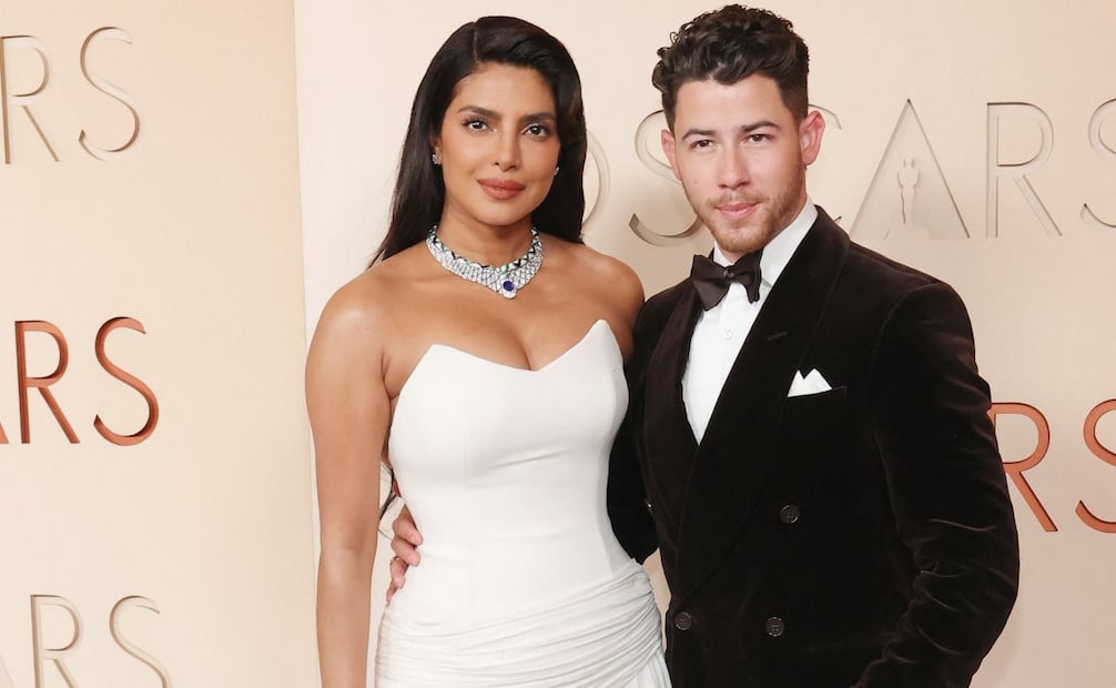 Priyanka Chopra en tendencia, en un vestido blanco estraples de Dior, con aires nupciales y Nick Jonas, su esposo, de esmoquin negro, sobrio. Foto: AFP