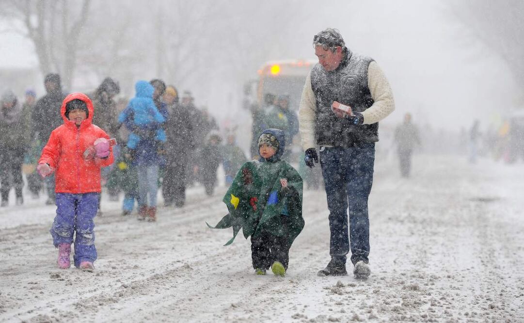 Ella, Cooper y Colin Reilly marchan a través de la nieve con efecto lago durante el desfile navideño anual de Hamburgo el 30 de noviembre de 2024 en Hamburgo, Nueva York. La tormenta del noreste que cerró un tramo de 90 millas de la autopista del estado de Nueva York y atascó el tráfico festivo en todo el país arrojó más de cuatro pies de nieve alrededor de Buffalo y sus suburbios del sur y se espera que continúe durante todo el fin de semana. Foto: AFP