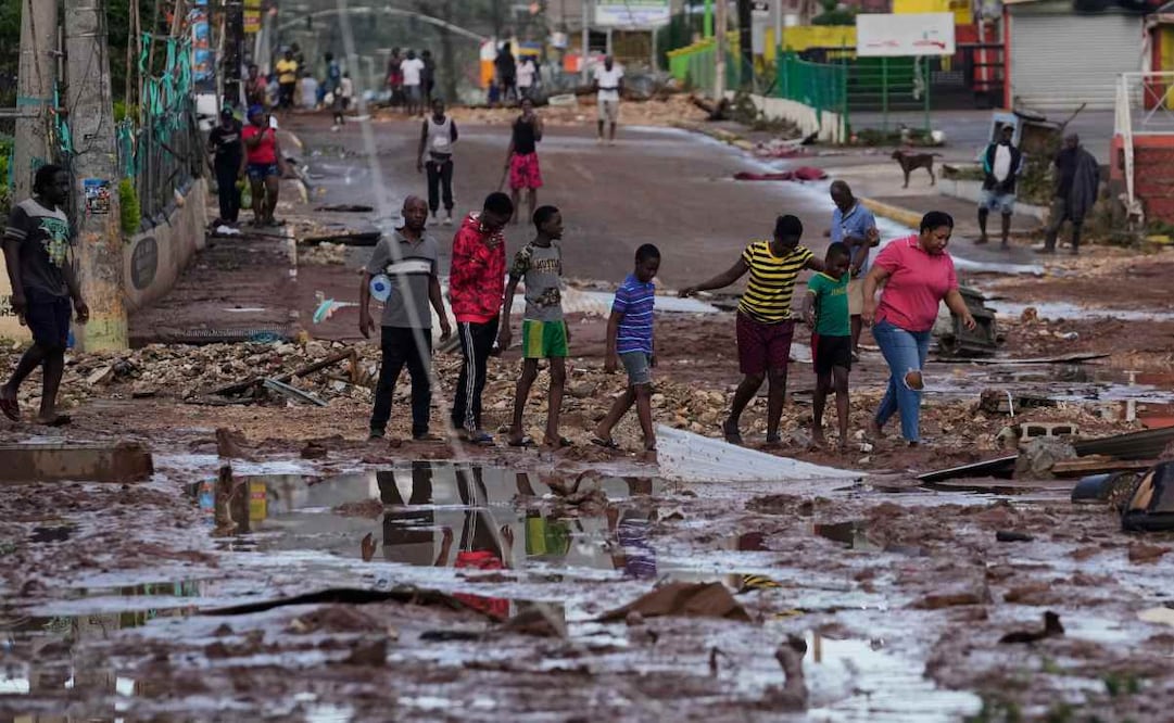 Personas caminan por Santa Cruz, Jamaica, el miércoles 29 de octubre de 2025, después del paso del huracán Melissa. Foto: AP