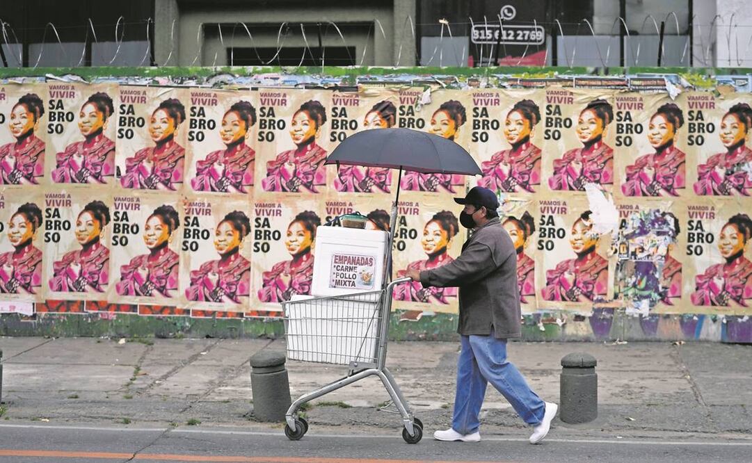 Un vendedor de empanadas, frente a propaganda de Francia Márquez, compañera de fórmula del candidato presidencial Gustavo Petro, de la coalición Pacto Histórico, en Bogotá. Foto: Fernando Vergara/AP