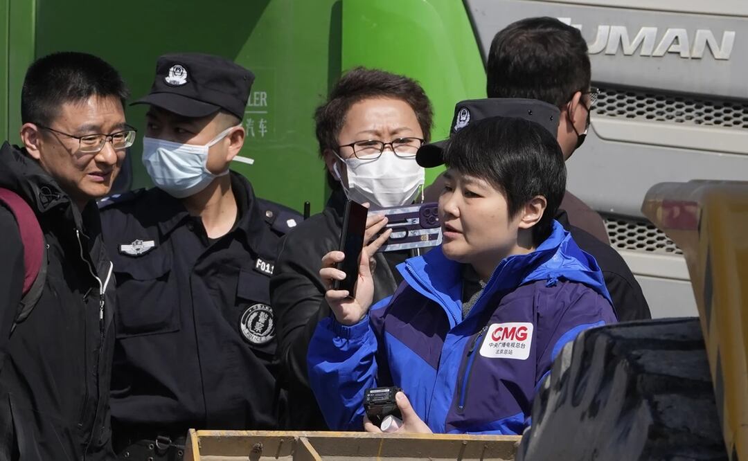 El personal de seguridad chino intenta expulsar a los periodistas de la escena de una explosión en la ciudad de Sanhe. Foto. AP