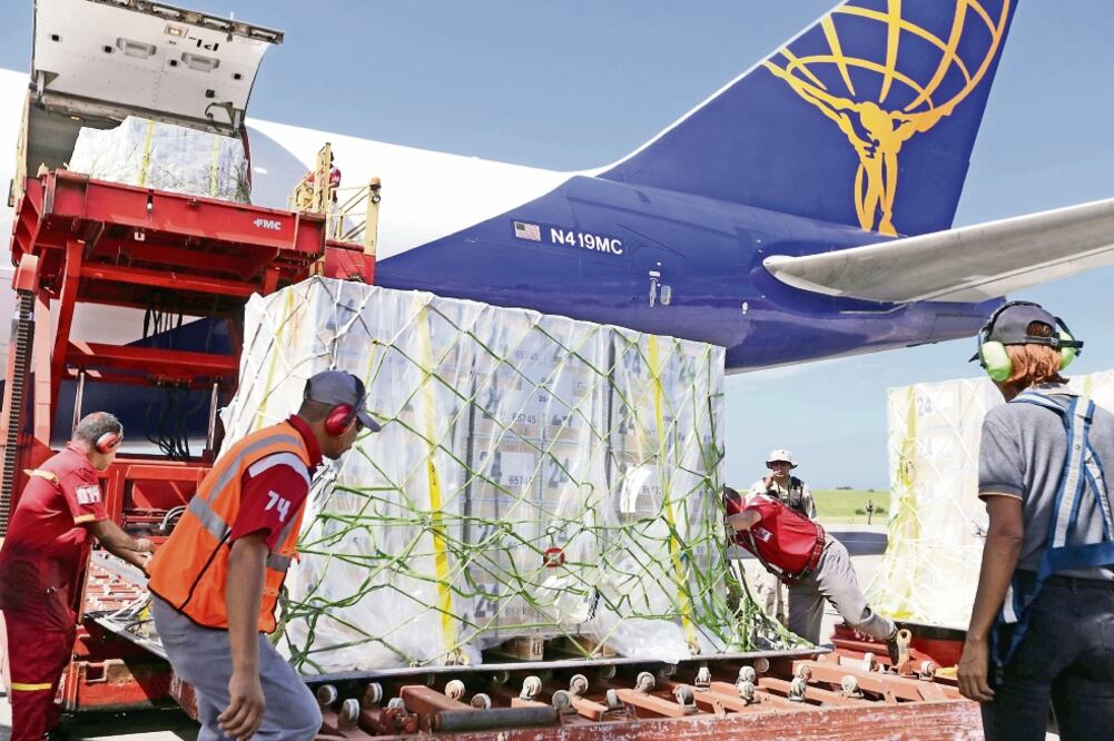 Trabajadores descargan los nuevos billetes del cono monetario nacional venezolano, en el Aeropuerto Internacional de Maiquetía, estado Vargas (XINHUA)
