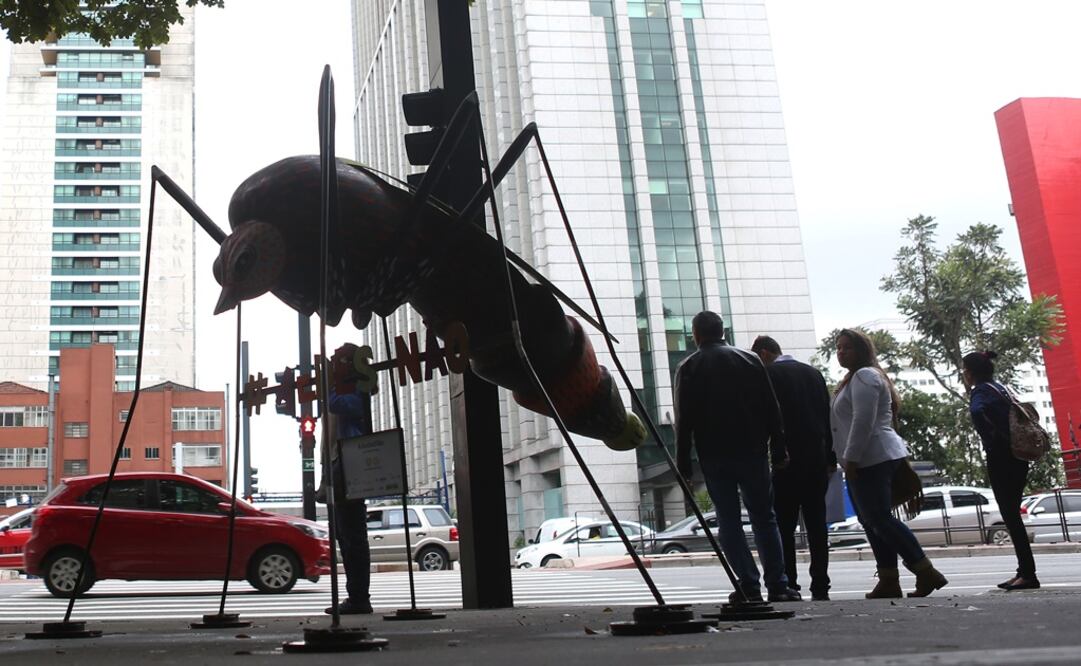 Personas caminan frente a la escultura de un mosquito "Aedes aegypti", creado por el artista Andre Farkas, en la ciudad de Sao Paulo, Brasil (Foto: Xinhua)