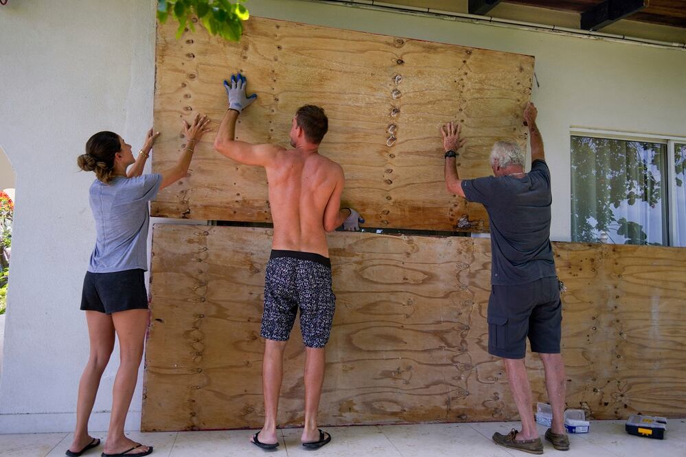 Residentes cubren las ventanas de sus casas, previo al arribo del huracán Beryl en Bridgetown, Barbados. FOTO: RICARDO MAZALAN. AP