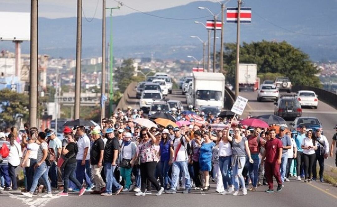 Empleados públicos de Costa Rica desfilan este lunes por una autopista de la capital de ese país en protesta por un proyecto tributario del gobierno del presidente costarricense, Carlos Alvarado, que busca enfrentar el problema del déficit fiscal. (Perió