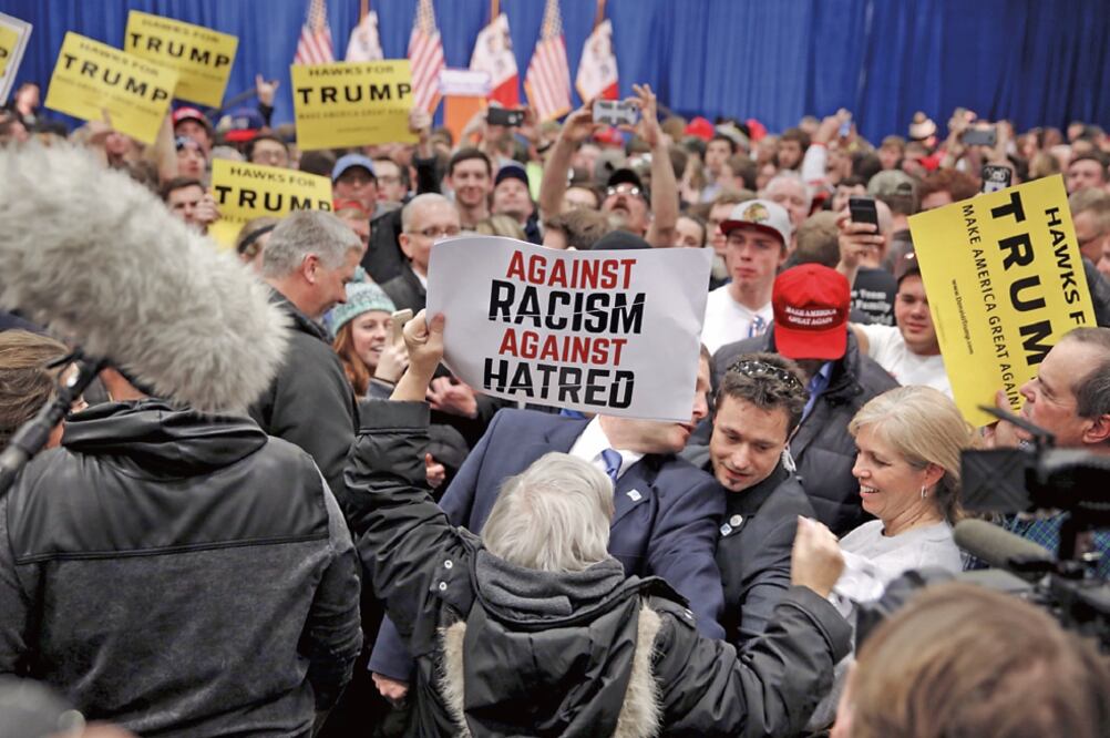 Un activista con una pancarta contra el racismo y el odio, durante una manifestación en rechazo a Trump, en Iowa, en enero pasado (ARCHIVO. REUTERS)