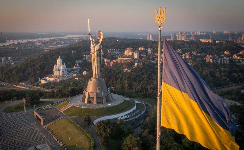 La bandera ucraniana ondea mientras trabajadores instalan el escudo en la estatua más alta del país, en Kiev. Foto: AP