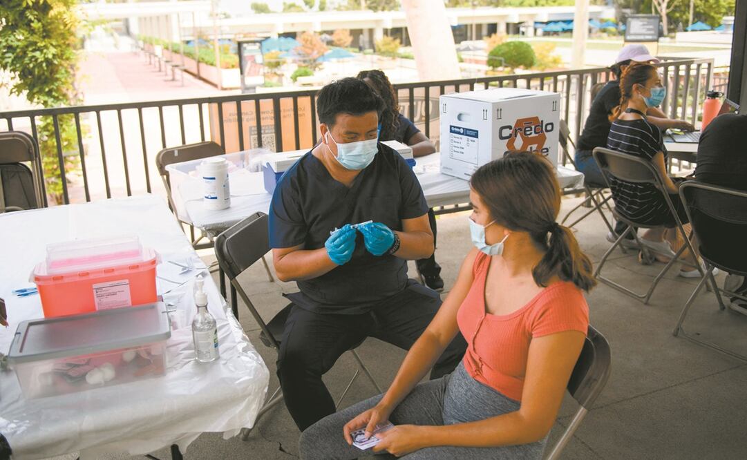 Una joven recibe en Long Beach, California, una primera dosis de la vacuna Pfizer contra el coronavirus. Foto: Patrick Fallon/ AFP.