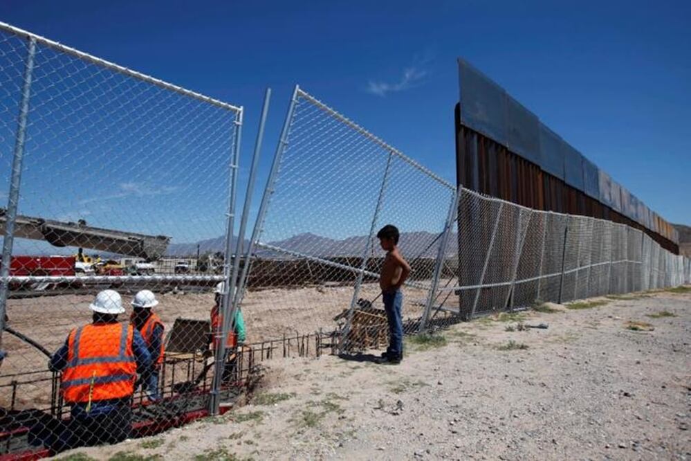 A boy looks at U.S. workers building a section of the U.S.-Mexico border wall at Sunland Park, U.S. opposite the Mexican border city of Ciudad Juarez, Mexico. REUTERS/Jose Luis Gonzalez