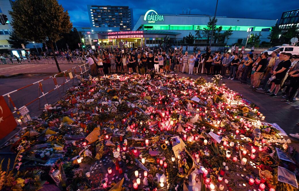 Personas observan una ofrenda colocada en memoria de las víctimas de un tiroteo, en el centro comercial Olympia en la ciudad de Múnich (Foto: EFE)