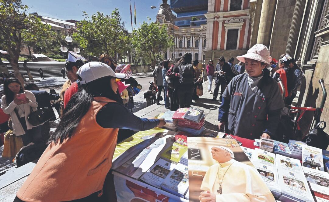 Una comerciante vende recuerdos del papa Francisco frente a la Catedral Metropolitana de La Paz, Bolivia. Foto: de AIZAR RALDES. AFP