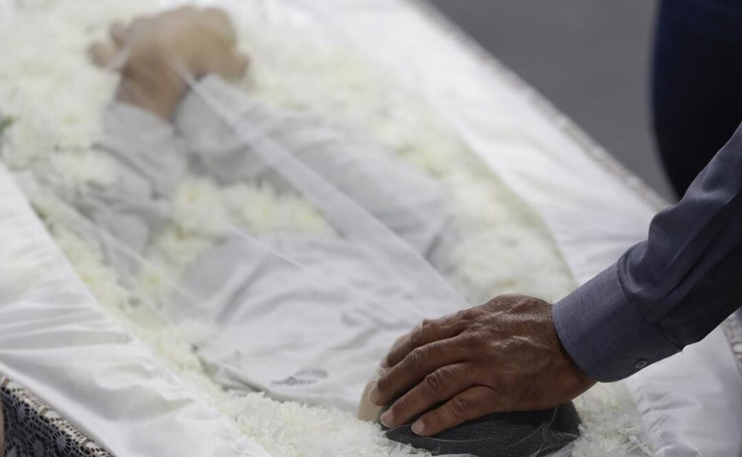 Un familiar coloca su mano en la cabeza de Caio Oliveira, víctima de un tiroteo en una escuela, durante un funeral colectivo para quienes murieron en Suzano. Foto: AP