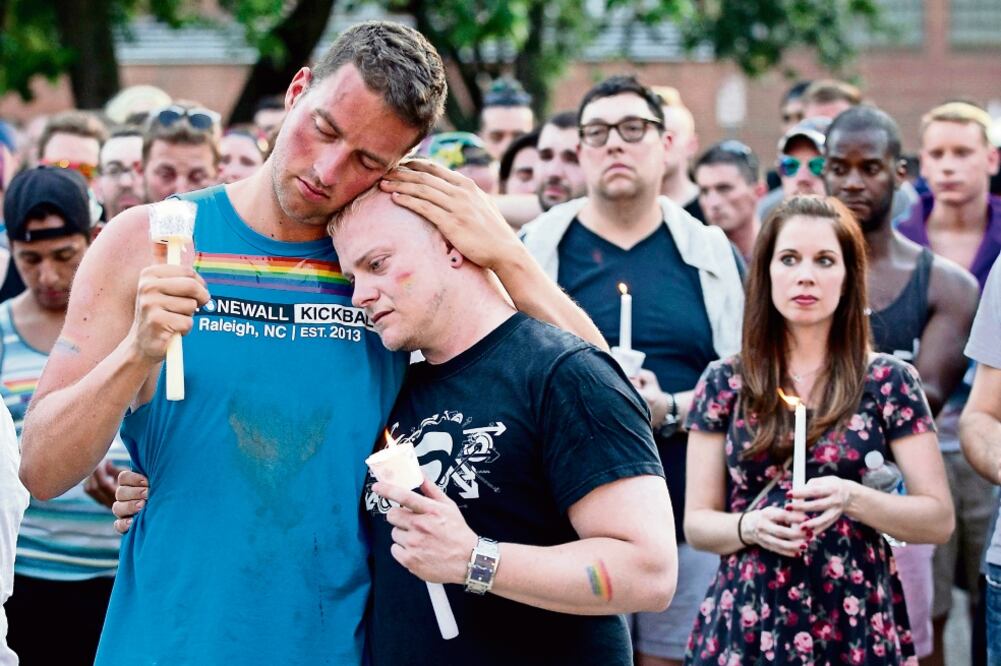 Una pareja se abraza durante la vigilia que se realizó ayer en Hargett Street, en Carolina del Norte, en honor al medio centenar de personas que perdió la vida durante el tiroteo (ROBERT WILLETT. AP)