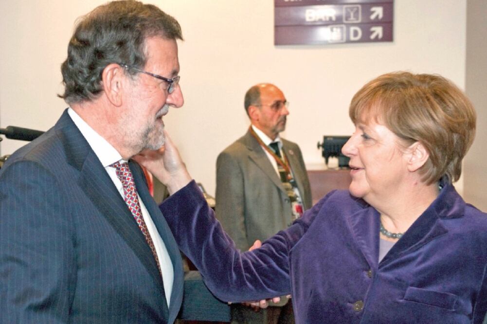 La canciller alemana hace un cariño al presidente del gobierno español, Mariano Rajoy, ayer, en Bruselas tras la agresión que éste sufrió el miércoles (HORST WAGNER. EFE)