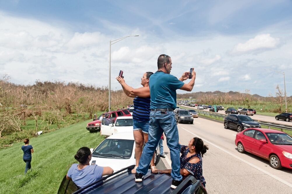 La gente hizo fila en un tramo de carretera donde había señal para los teléfonos móviles, en Dorado, Puerto Rico (ALVIN BÁEZ. REUTERS)