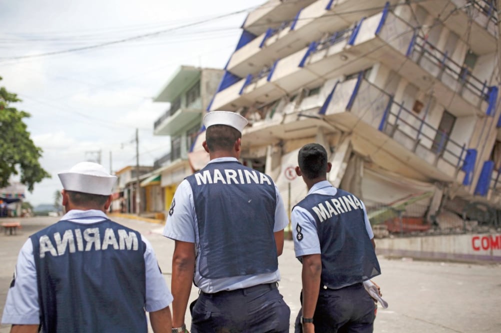 Tres oficiales de la Marina caminan cerca de un edificio colapsado en Matías Romero, Oaxaca. El sismo derribó cientos de inmuebles y dejó al menos 61 personas fallecidas en las zonas afectadas. (FELIX MARQUEZ. AP)