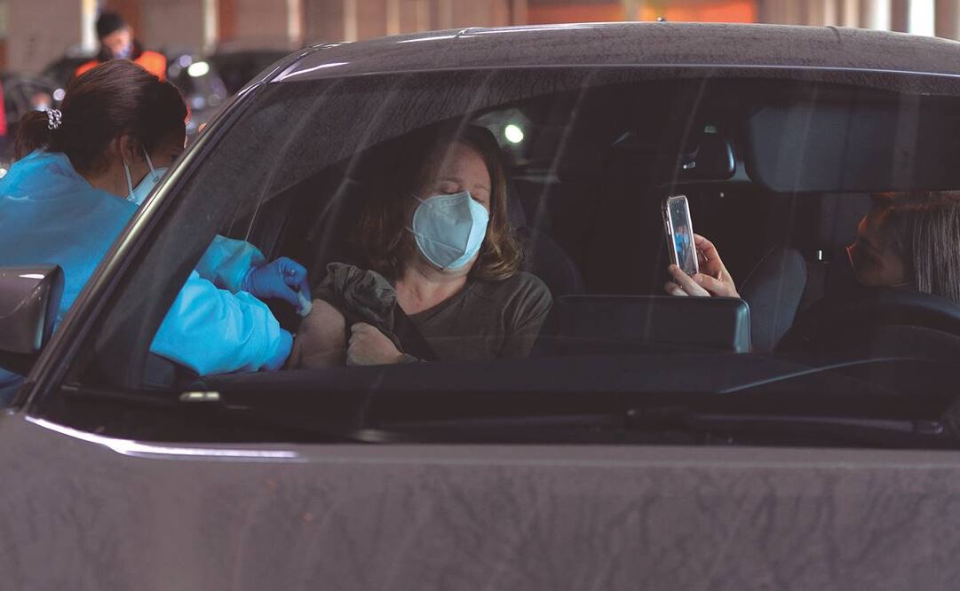 Una empleada sanitaria administra una dosis de AstraZeneca a una mujer en Huelva, España. Foto: Cristina Quicler/ AFP.