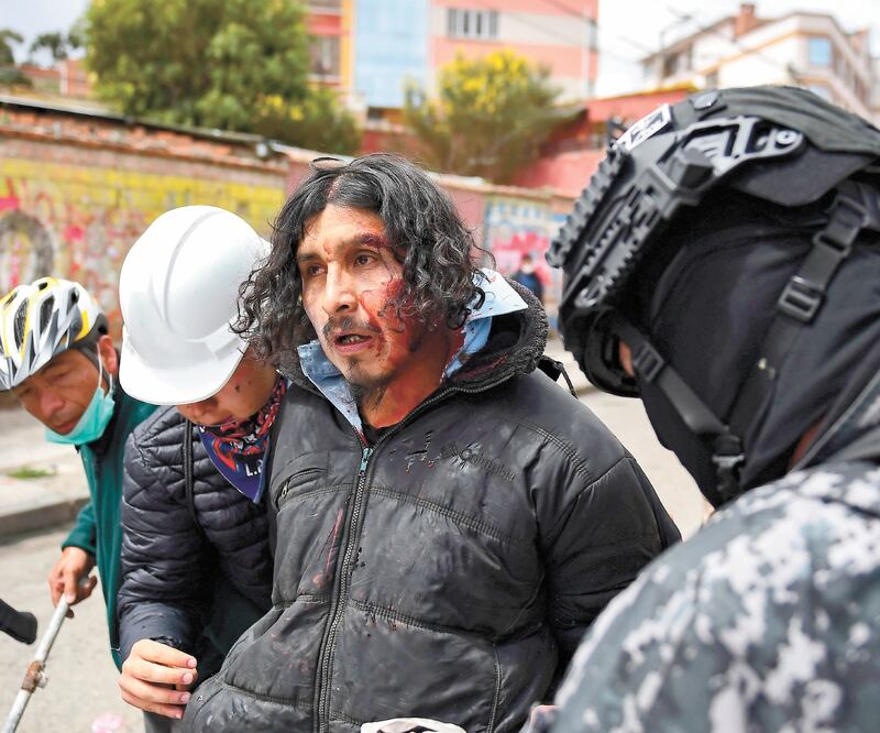 Se intensifica la crisis. Policías de Bolivia detuvieron a un hombre herido durante las protestas por el golpe de Estado. Foto/CARLOS GARCÍA RAWLINS. REUTERS