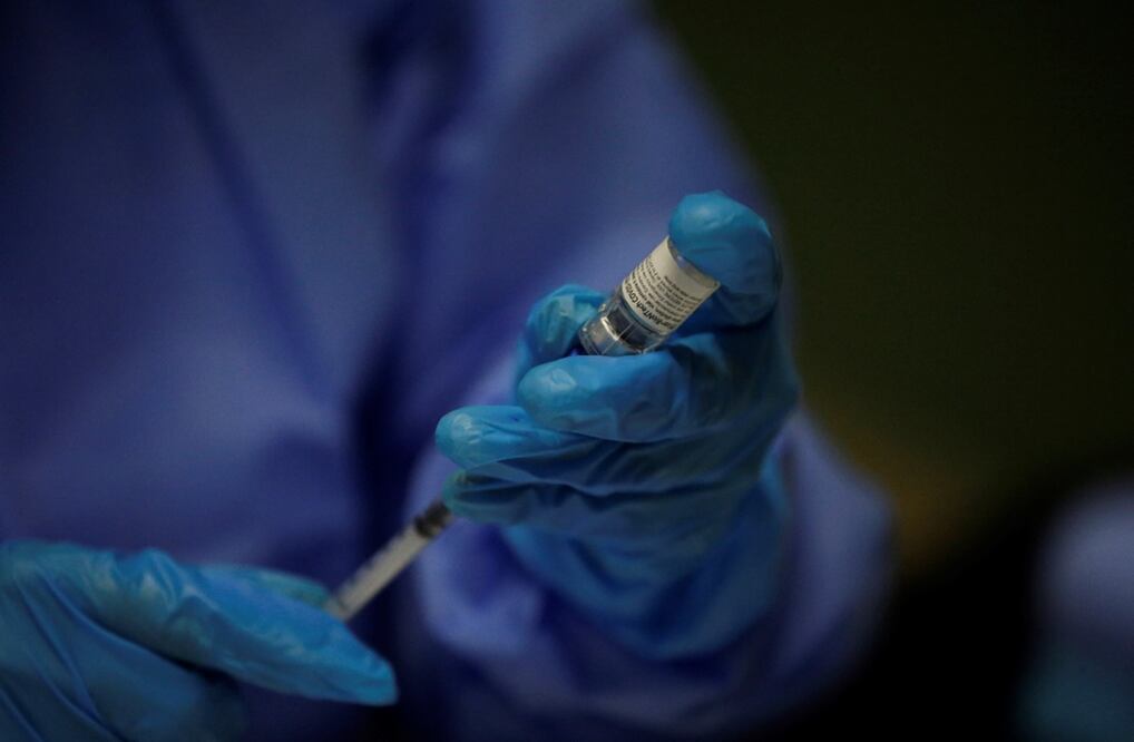 Personal de salud se prepara para aplicar la dosis principal de la vacuna Pfizer. Foto: EFE, archivo 