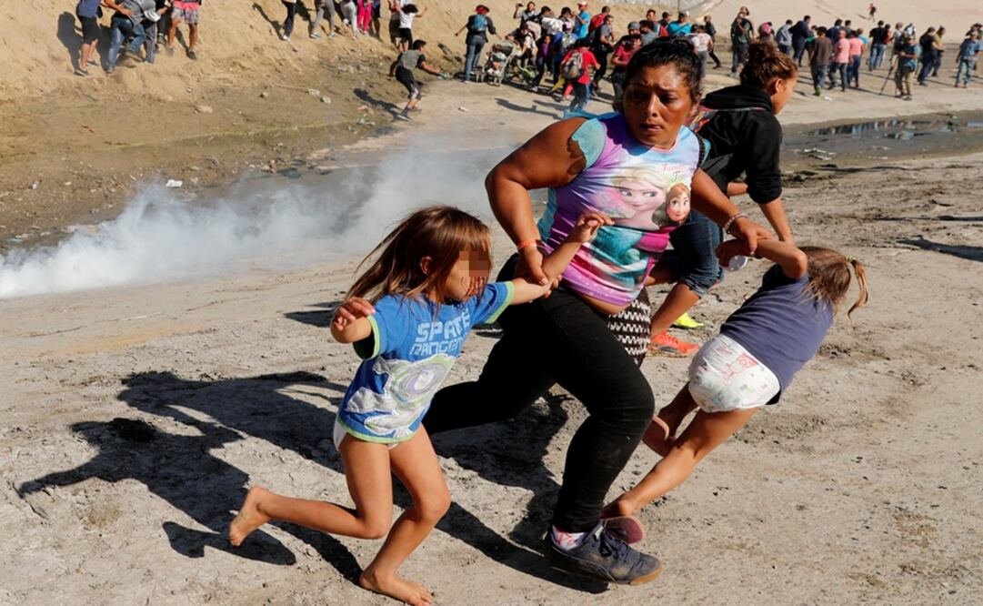 Migrantes centroamericanos huyen de los gases lacrimógenos que fueron lanzados por la patrulla fronteriza y soldados de Estados Unidos, cerca de la frontera con México. (KIM KYUNG-HOON. REUTERS)