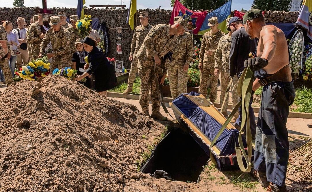 Militares y trabajadores del cementerio entierran a un ucraniano que murió luchando contra las tropas rusas en Donetsk. Foto: AFP