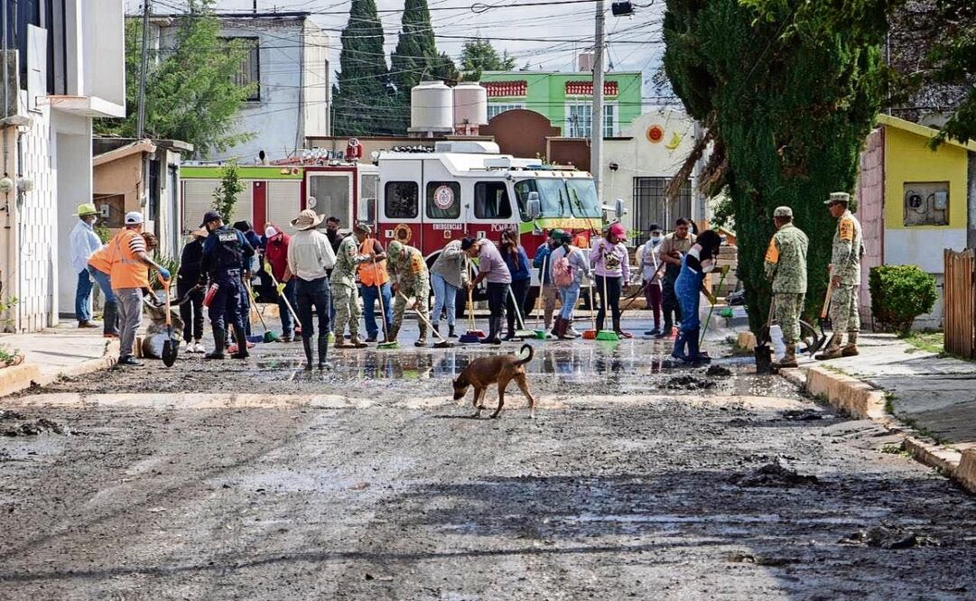 Personas armadas con escobas y cubetas recorrieron las 50 calles afectadas en Los Tuzos, junto a elementos de la GN, por la inundación de aguas negras. Foto: Especial