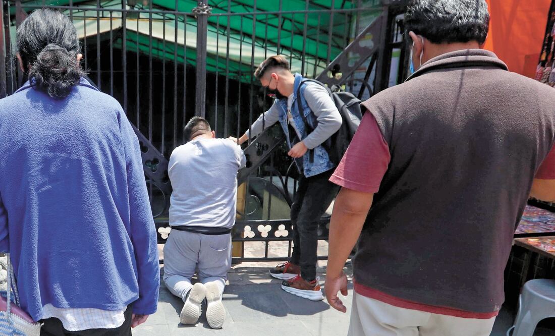 Frente al portón principal de la iglesia de San Hipólito, que se encuentra cerrado con cadena y candado desde hace tres meses, los fieles a San Judas Tadeo se hincan para rezarle y pedirle que los ayude a resolver sus problemas. BERENICE FREGOSO. EL UNIVE