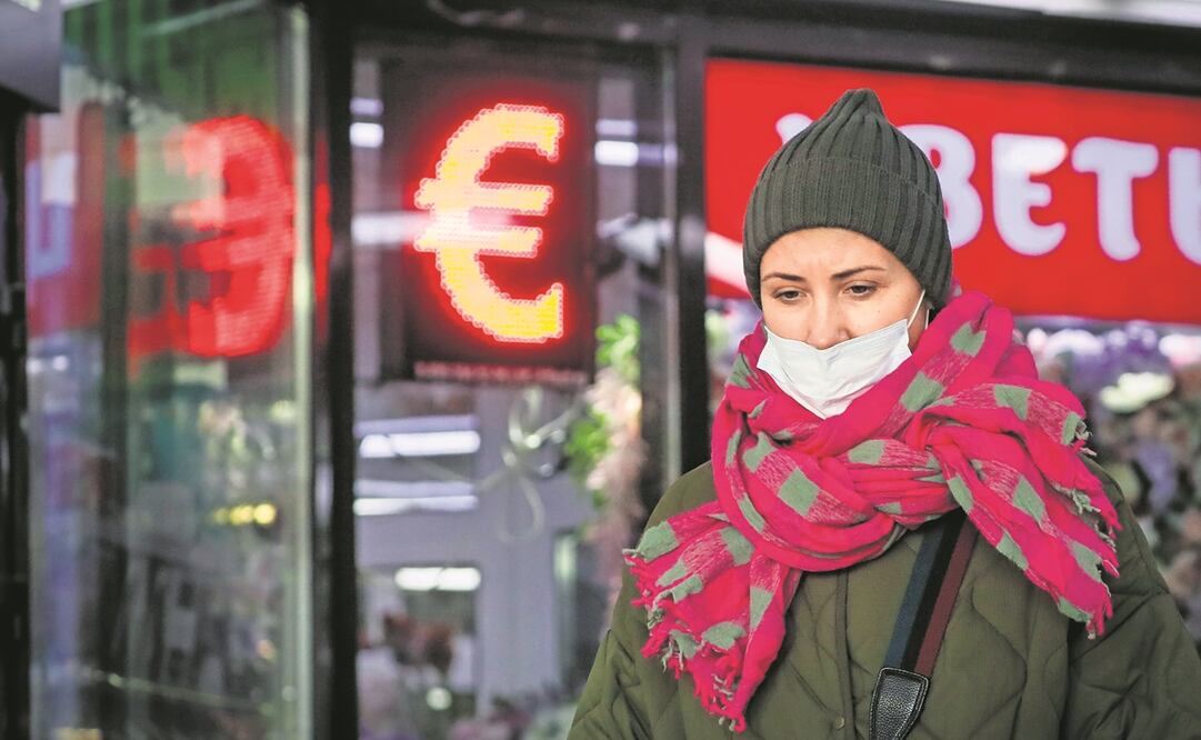 Una mujer rusa pasa frente a un panel de una oficina de cambio en Moscú. El rublo cayó el lunes 30% frente al dólar y el euro. Foto: YURI KOCHETKOV/ EFE