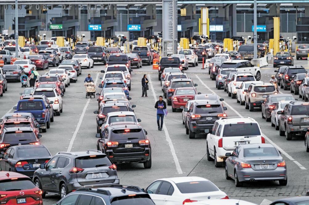 Vendedores ambulantes aprovechan las largas filas en el cruce fronterizo de San Ysidro, donde la gente espera horas para cruzar hacia Estados Unidos. Foto/ ARCHIVO AFP