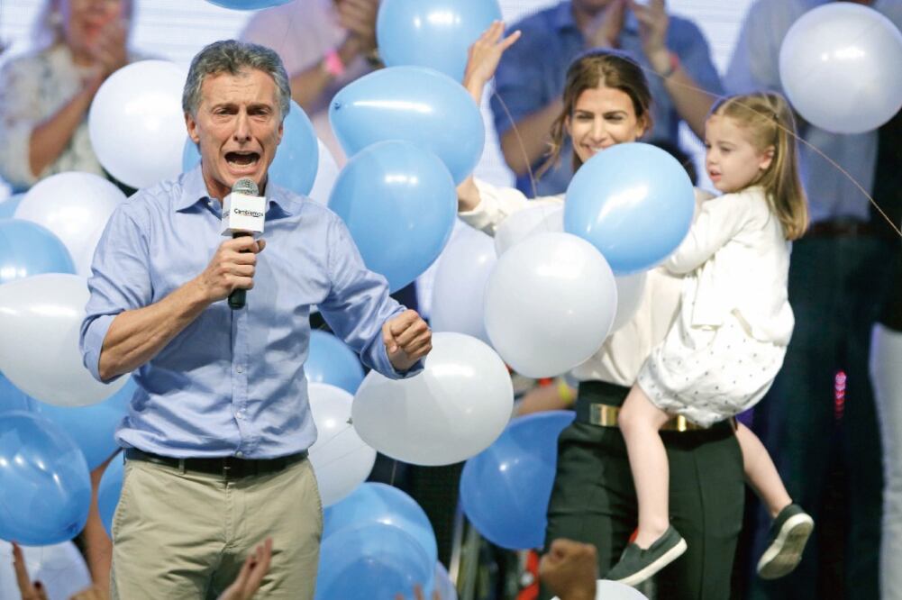 El opositor Mauricio Macri celebra su victoria en compañía de la próxima primera dama argentina, Juliana Awada, y la hija de ambos, en Buenos Aires (RICARDO MAZALAN. AP)