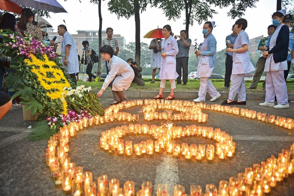 Con minutos de silencio, crisantemos blancos y pancartas, la gente del puerto de Tianjín realizó ayer ceremonias para recordar a las víctimas de las explosiones de la semana pasada (YOU SIXING. XINHUA)