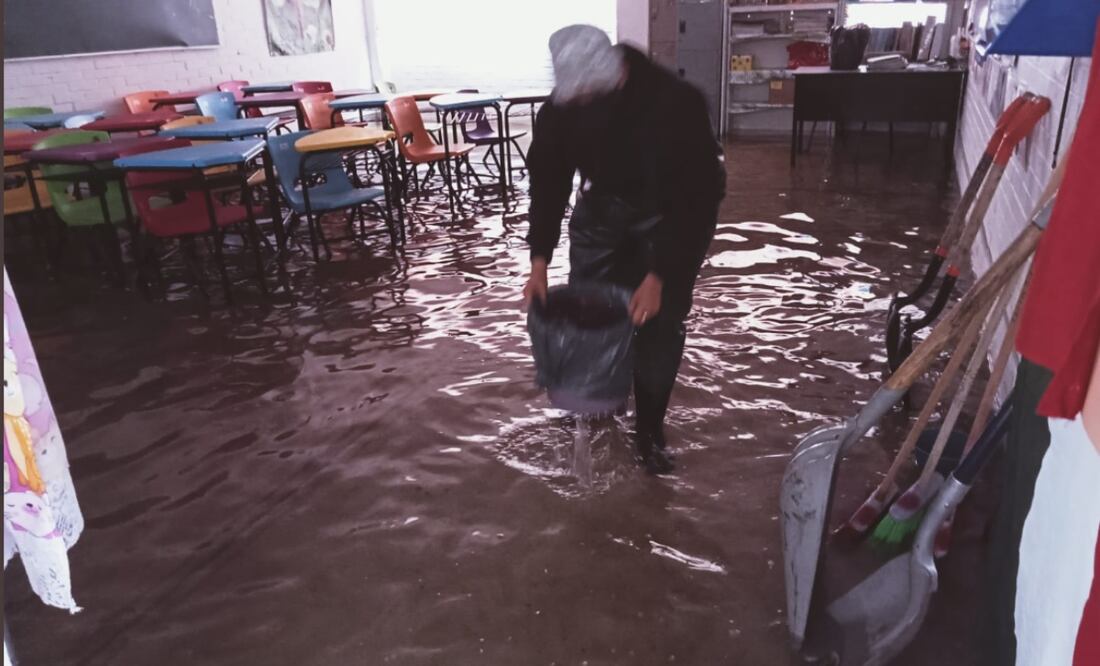 foto: Especial/El Universal/ Protección civil local acudieron al llamado de padres de familia y maestros para retirar el agua pluvial que alcanzó una altura de hasta 50 cm, debido al drenaje tapado